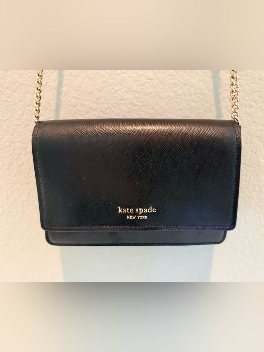 Kate Spade black leather purse with gold accents, crossbody strap